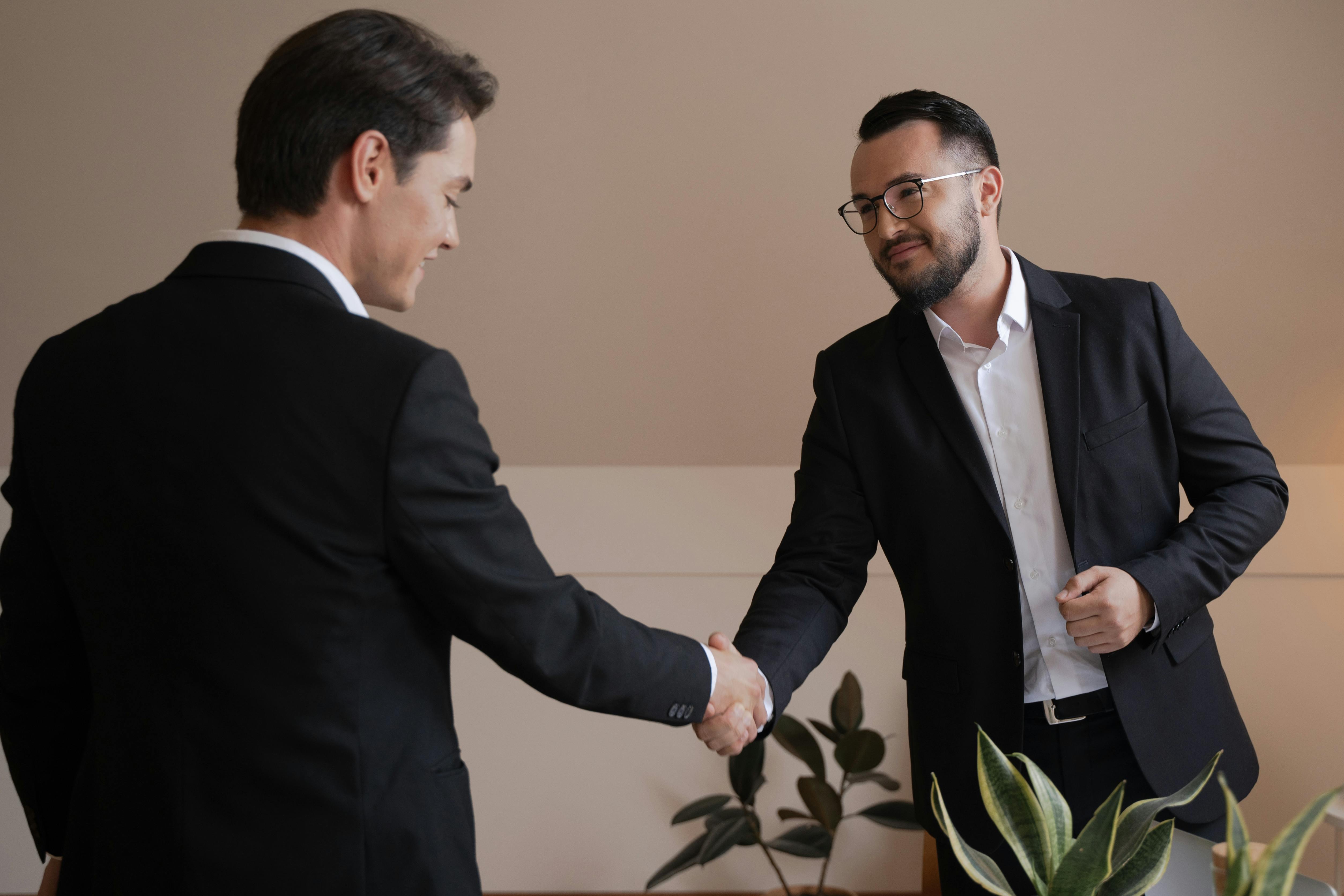 Two people shaking hands and smiling
